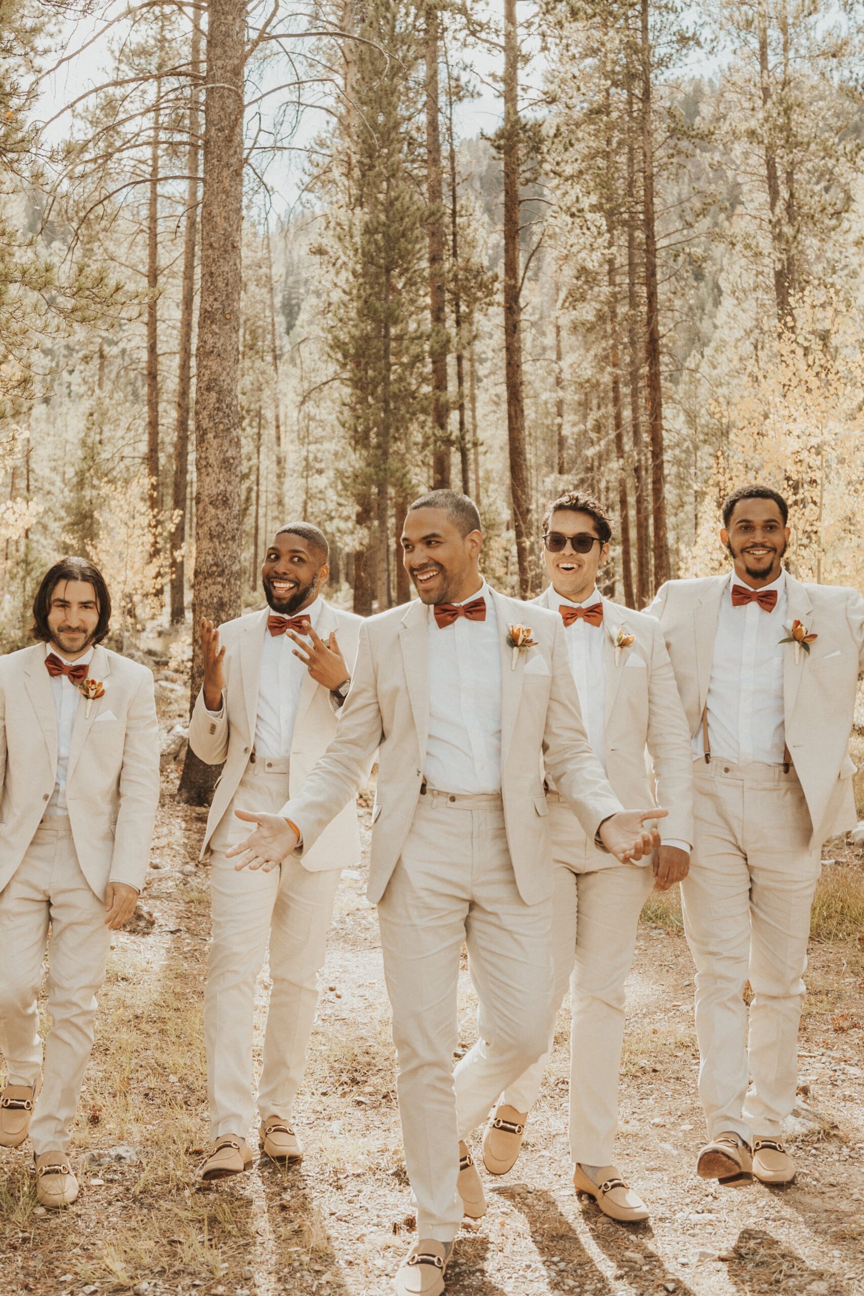 groom laughing with groomsmen in taupe linen suits