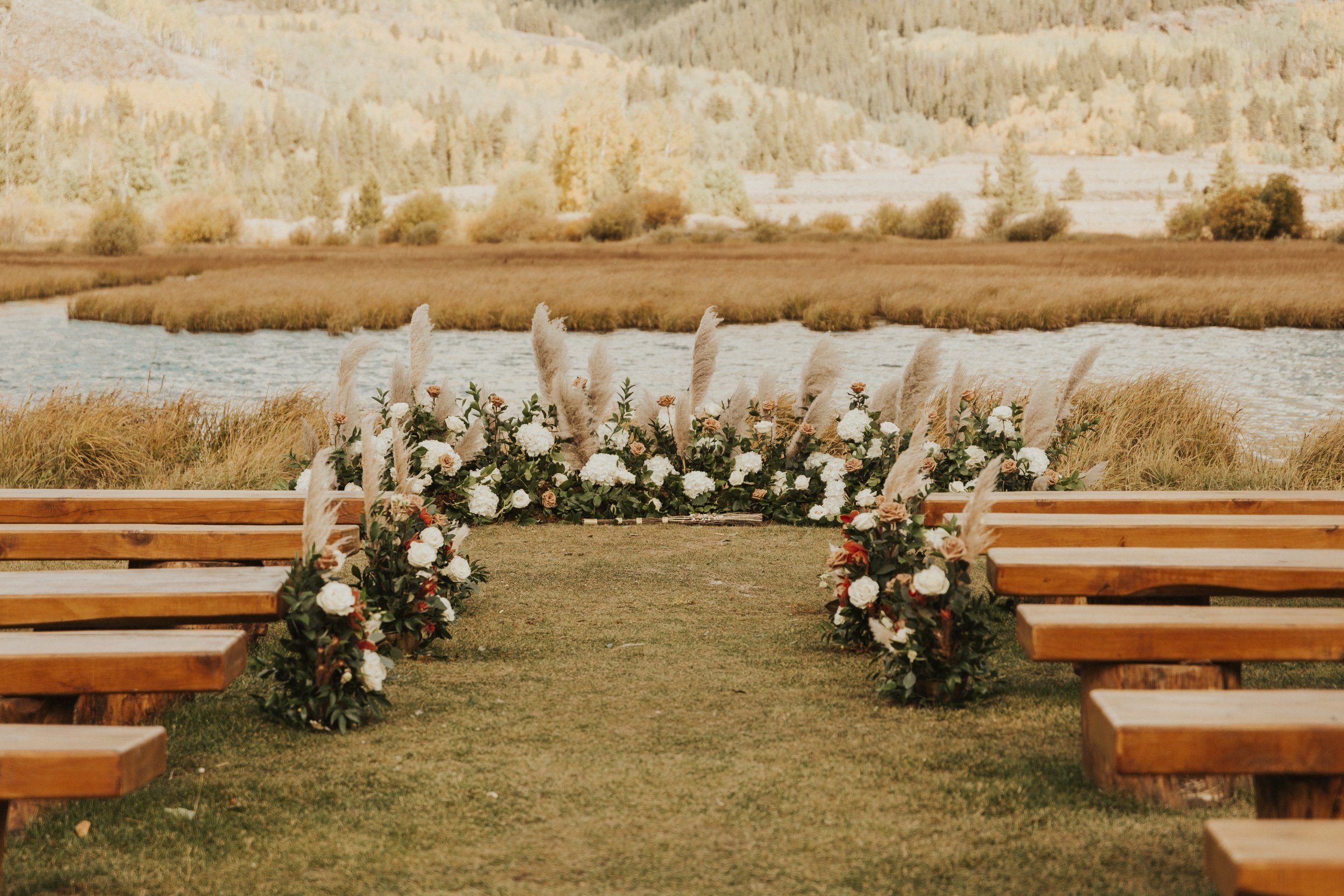 outdoor ceremony at Camp Hale wedding with wood benches