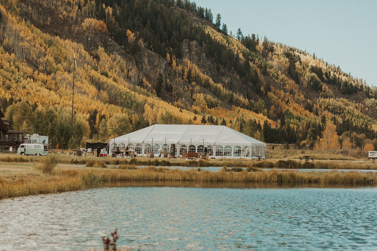 view of reception tent at Camp Hale wedding with Colorado mountains in distance