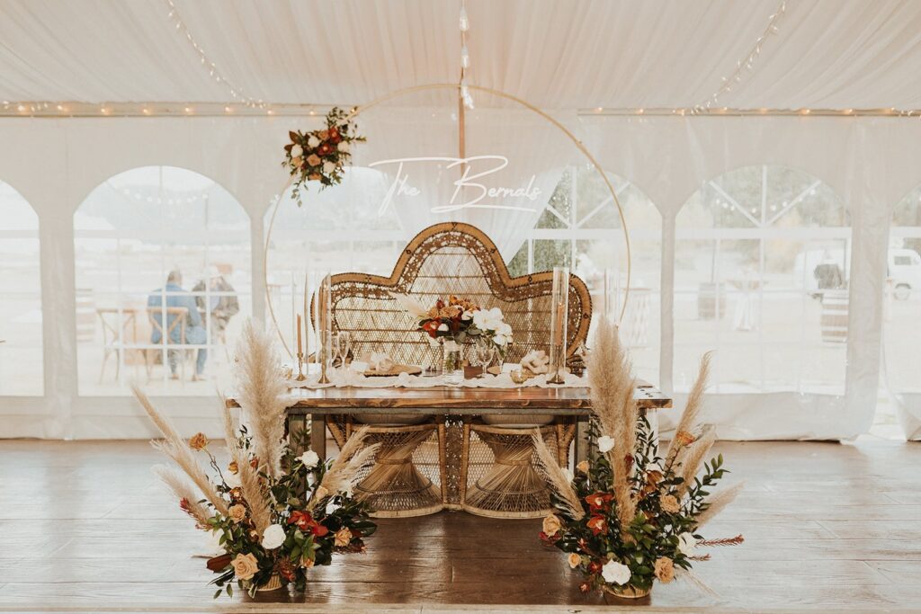 sweethearts table with boho decor at tented wedding reception in Colorado